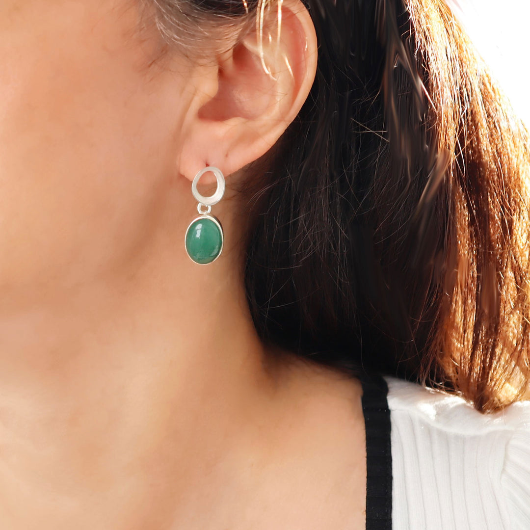 A large 925 silver and green aventurine gemstone drop earring worn by a woman with dark hair.