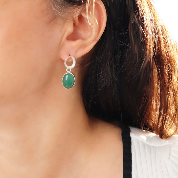 A large 925 silver and green aventurine gemstone drop earring worn by a woman with dark hair.