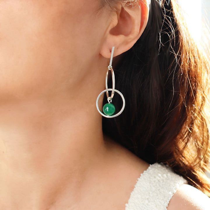 Close-up of a 925 sterling silver earring with a green aventurine gemstone bead worn by a woman with dark hair.
