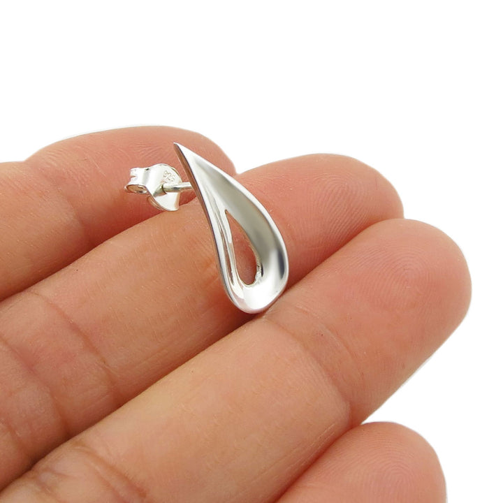 Solid 925 sterling Silver teardrop-shaped earring with a curved edge held between fingers on a white background