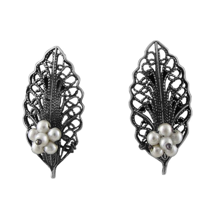 A pair of filigree wire work 925 sterling silver mexican stud earrings with seed pearls on a white background