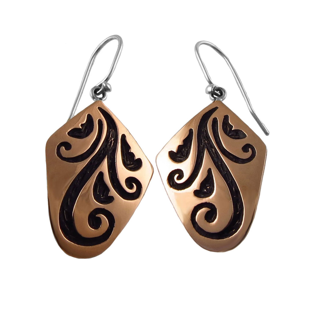 Pair of copper and 925 silver earrings for women with black vine pattern engravings on a white background