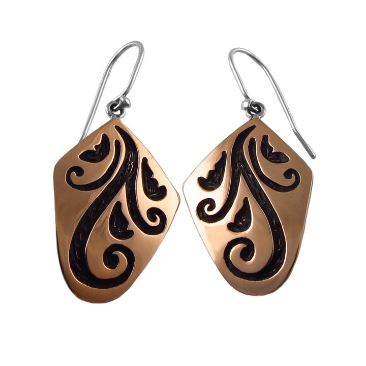 Pair of copper and 925 silver earrings for women with black vine pattern engravings on a white background