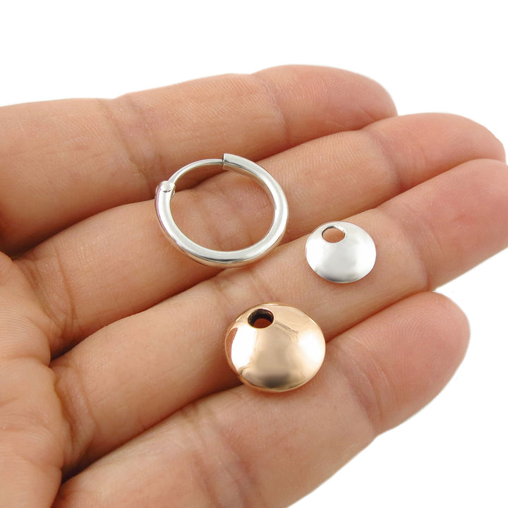 A 3 in 1 detachable hoop earring with copper and silver parts that can be removed, held in a hand on a clear background. 