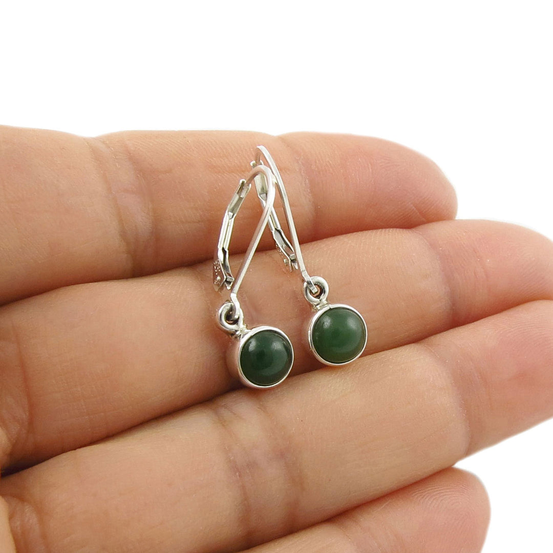 925 Silver earrings with lever back hooks and green jade gemstones held in a woman's hand against a white background