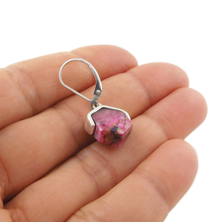 925 silver pink purple spiny shell earring held in a woman's hand against a white background