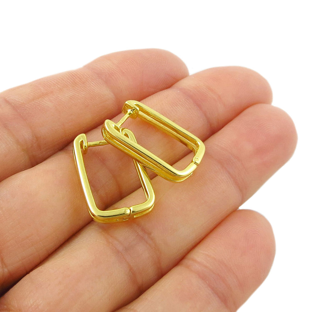 9ct gold plated rectangle hoop earrings held in a person's hand against a plain white background.