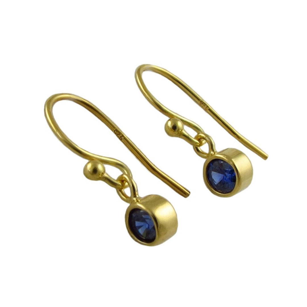 A pair of gold earrings with round bezel-set deep blue sapphire gemstones, shown on a plain white background.