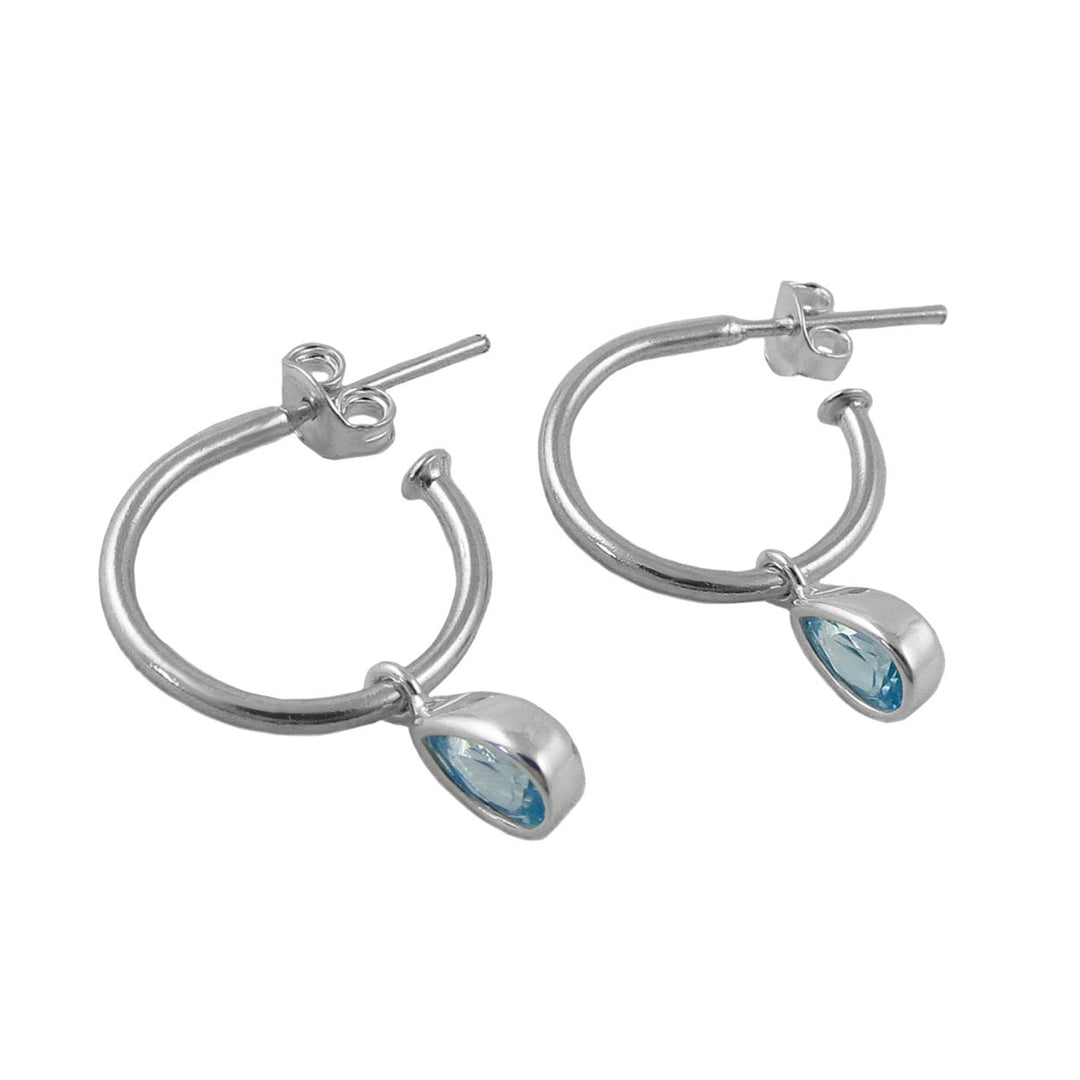 A pair of 925 silver hoop earrings with teardrop-shaped light blue March birthstone aquamarine gemstone drops, shown on a plain white background.