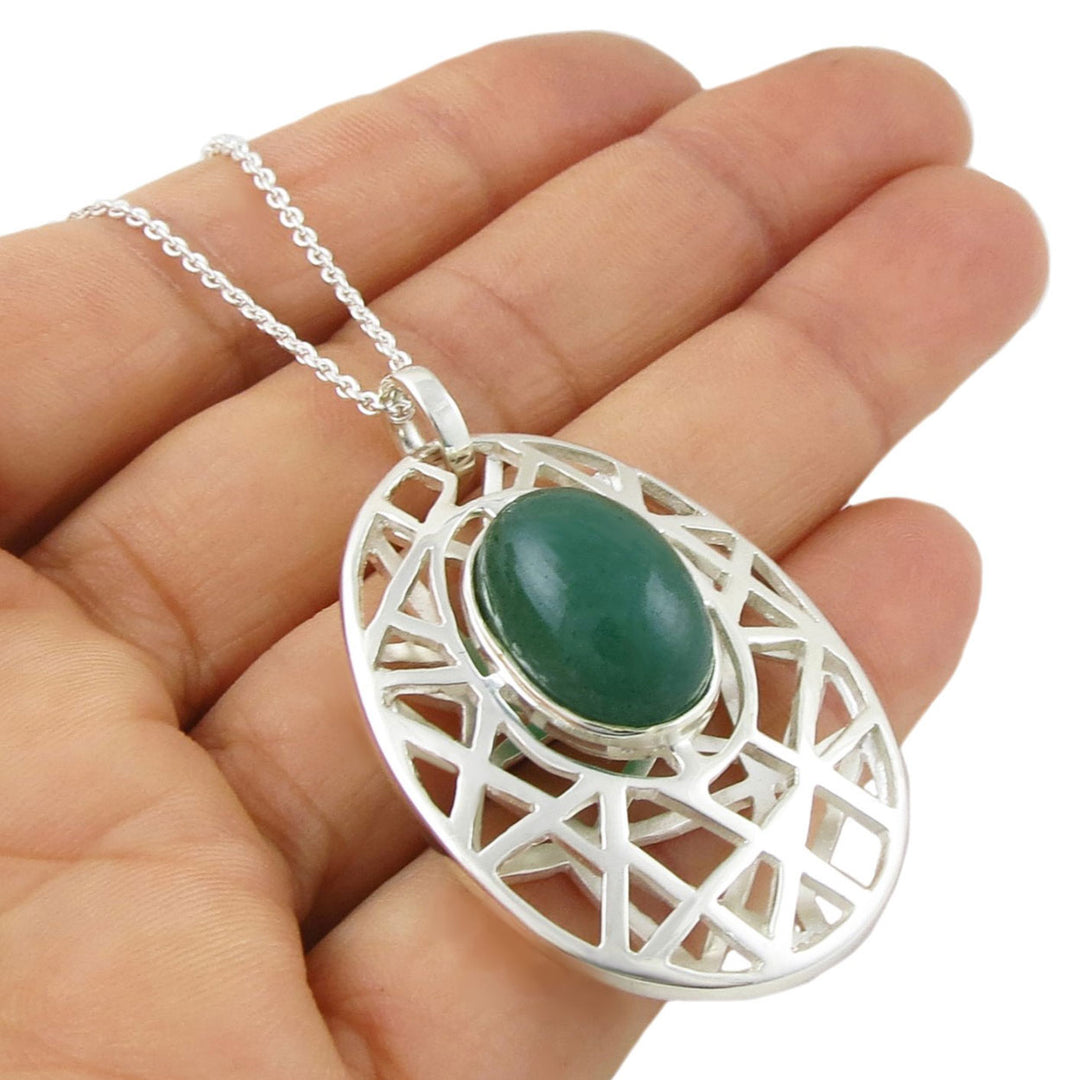 Bold green aventurine gemstone and UK 925 sterling silver large pendant and chain necklace held in a perosn's hand. 