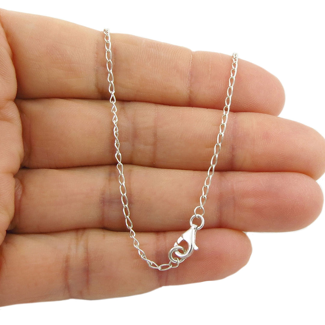 Silver chain necklace held between fingers to show the lobster claw clasp on a white background