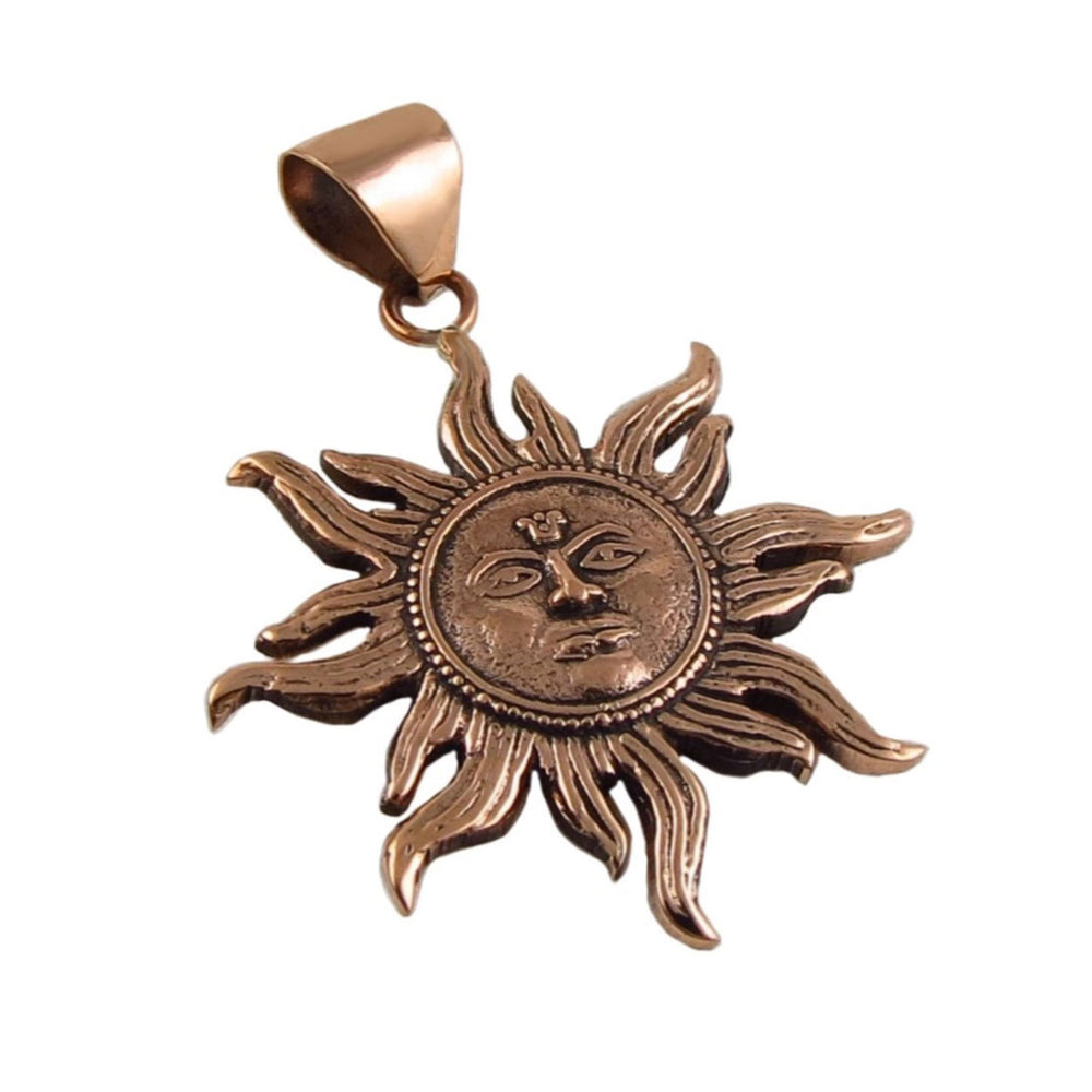Copper sun-shaped pendant with face design on a white background