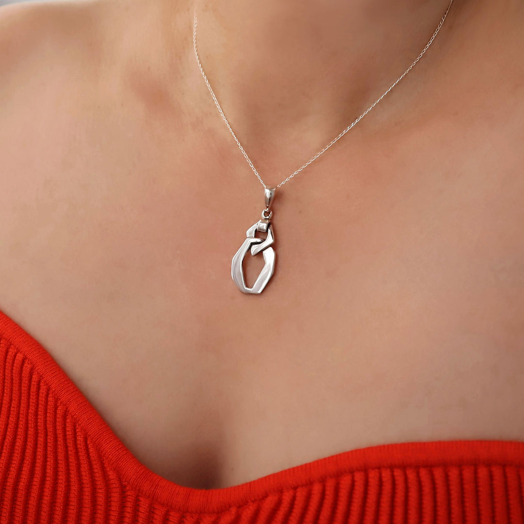 Sterling silver chunky curb link pendant and chain necklace on a woman wearing a red top.
