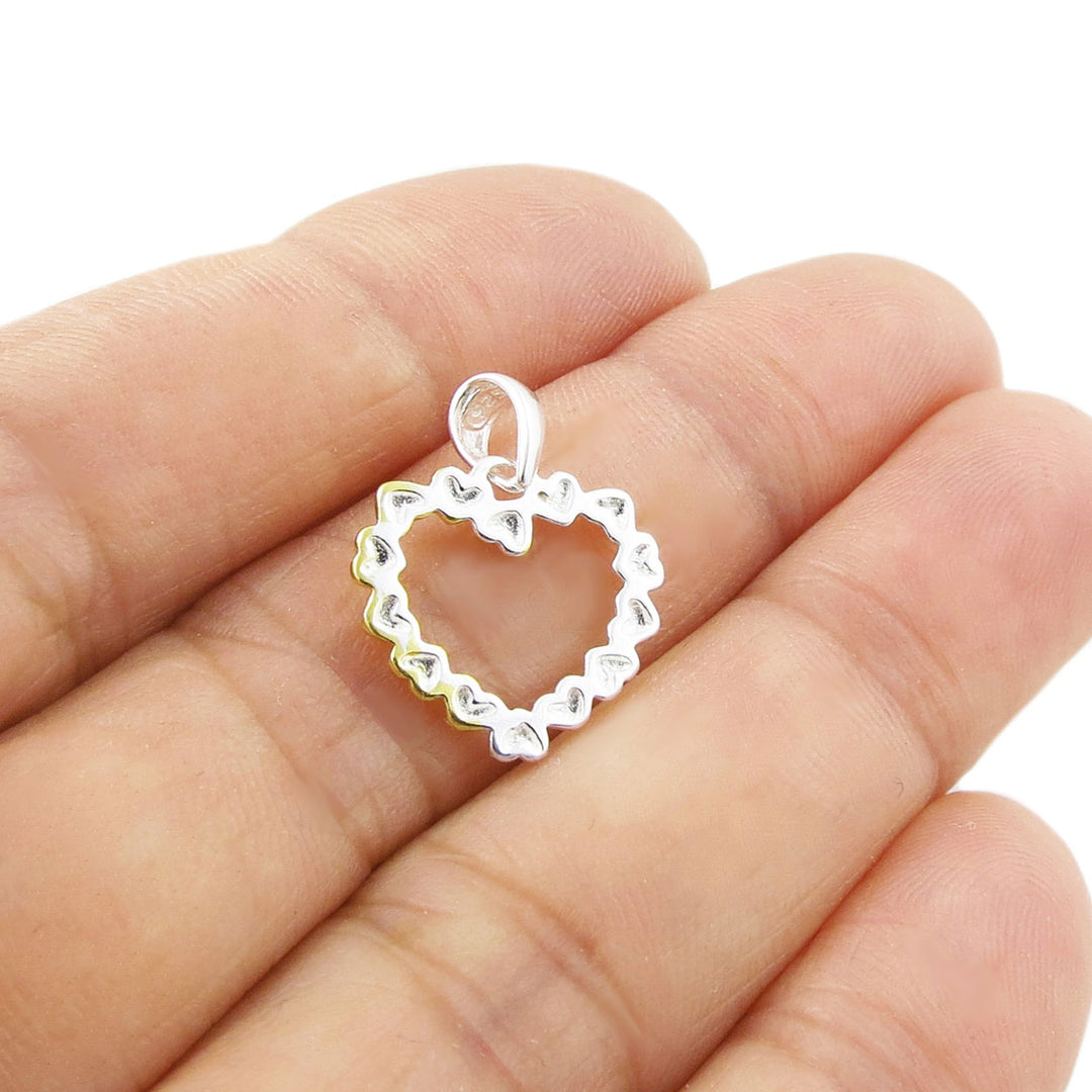 925 silver heart-shaped pendant held upside down between fingers on a white background