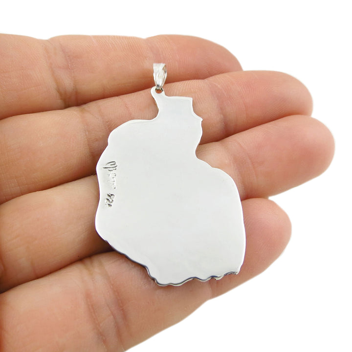 A large 925 sterling silver pendant held upside down in a hand to show the Maaria Belen Nilson Mexico 925 halllmark against a white background