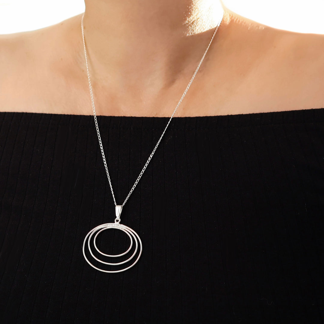 Sterling 925 silver pendant and chain statement necklace worn by a woman in a black off the shoulder top