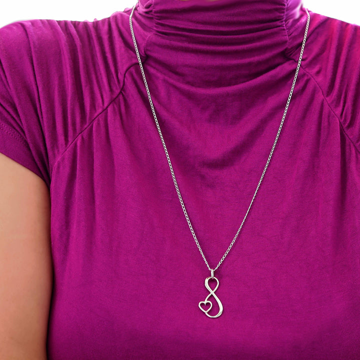 925 Silver necklace with a heart and infinity symbol pendant worn by a woman in a a purple shirt