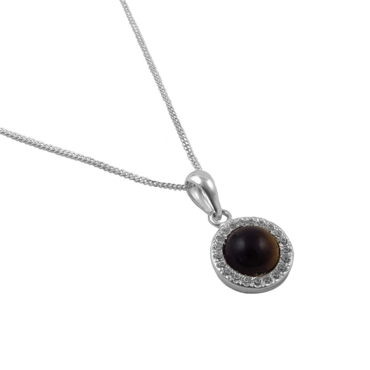 A 925 silver pendant necklace featuring a round dark brown tiger's eye stone surrounded by a halo of small clear stones, suspended from a silver chain on a white background.