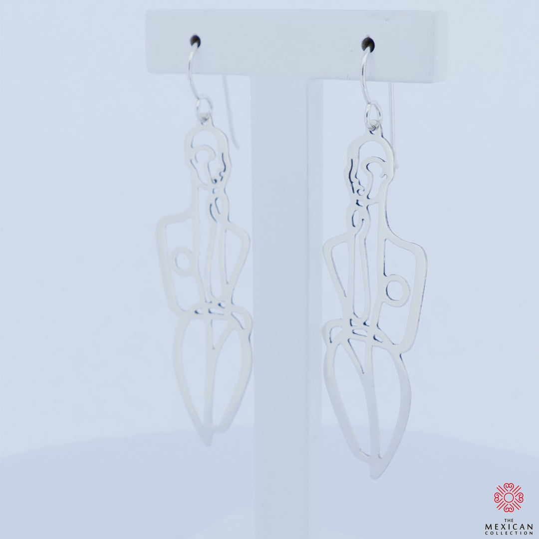 Large 925 silver earrings in the shape of female fashion silhouettes revolving on an earring stand against a white background. 
