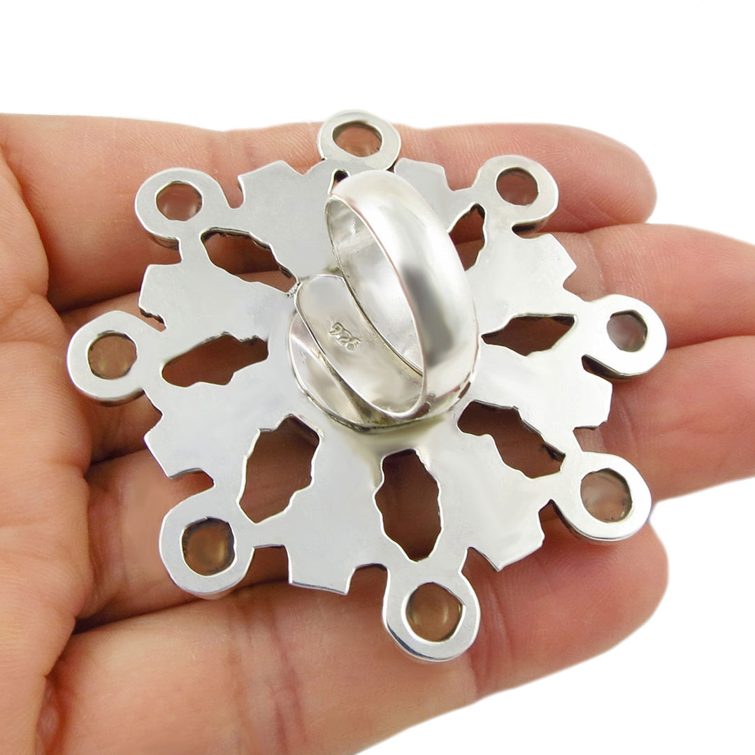 The reverse of a large handmade silver cocktail ring showing an adjustable spiral shank and UK hallmark. 