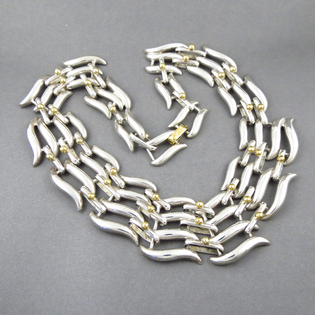 Sterling Silver and gold Tane Mexican necklace on a gray background