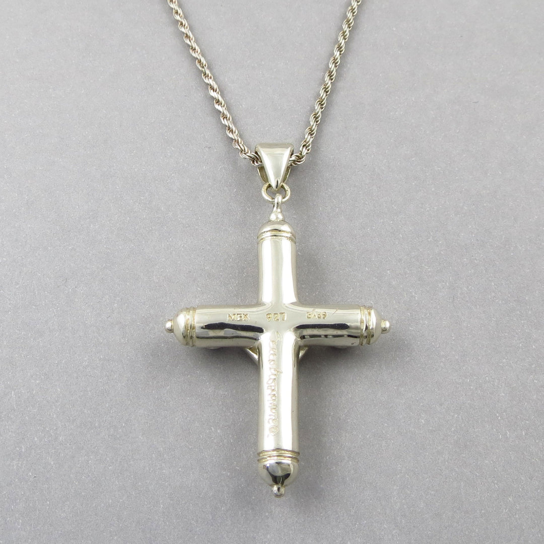 A large solid sterling 925 Silver cross pendant on a rope chain with a Mexican Sergio Bustamente hallmark against a gray background