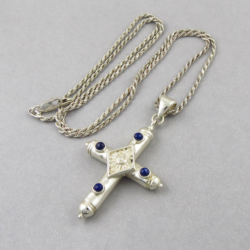 Sergio Bustamente sterling 925 silver cross pendant with blue lapis lazuli gemstones on a gray background