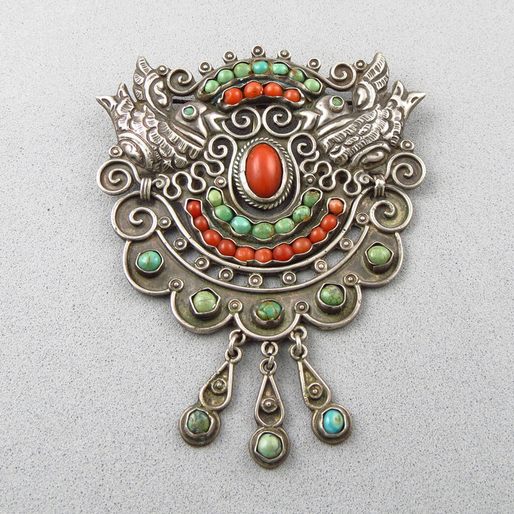 Large early MATL Mexican 925 silver brooch with colorful coral and turquoise stones on a light gray background