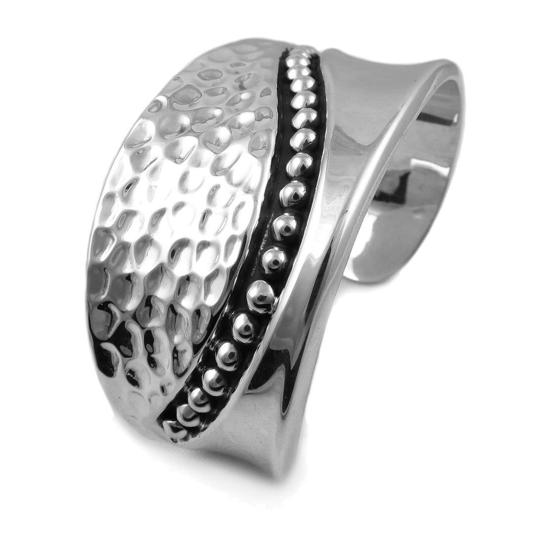 Chunky sterling ilver bracelet cuff with a hammered and polished mixed finish pattern on a white background. 