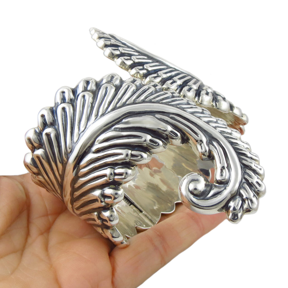 A large 925 Mexican sterling silver taxco fern clamper cuff held in a person's hand